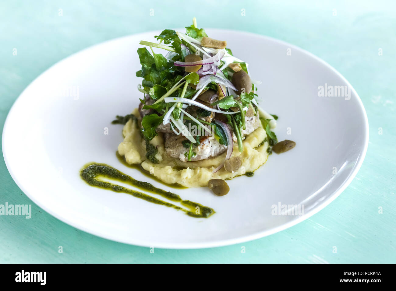 Mashed potato with fish steak and salad on white plate Stock Photo