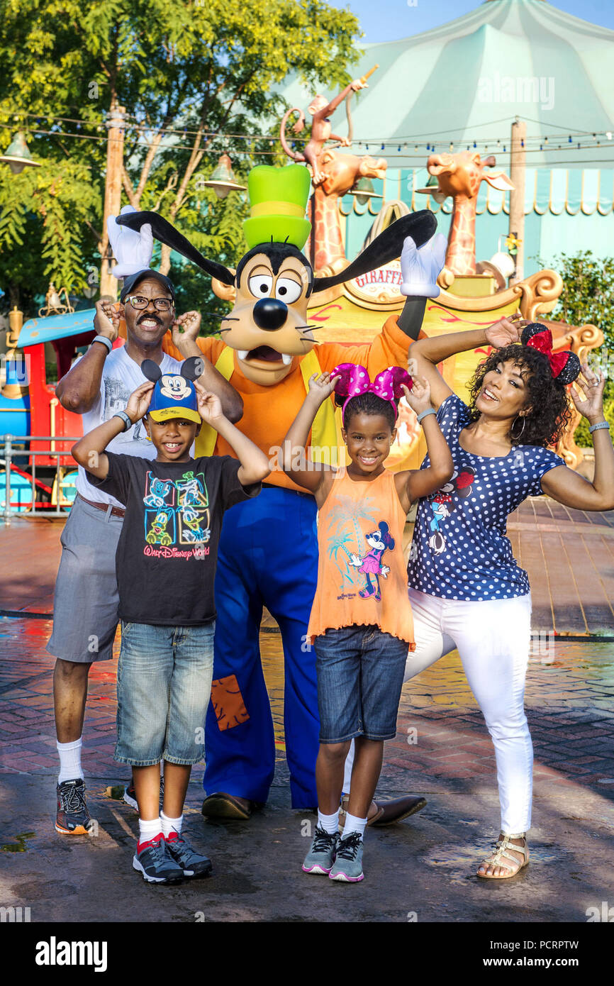 LAKE BUENA VISTA, FL: Actors Angela Bassett (right) and Courtney B. Vance (left) strike a pose June 19, 2015 with Goofy along with their twins Slater (front left) and Bronwyn (front right) at Magic Kingdom Park in Lake Buena Vista, Fla. The family visited the theme park while on vacation at Walt Disney World Resort. at Walt Disney World Resort in Lake Buena Vista, Florida.  People:  Angela Bassett and Courtney B. Vance visit Disney World in Florida Stock Photo