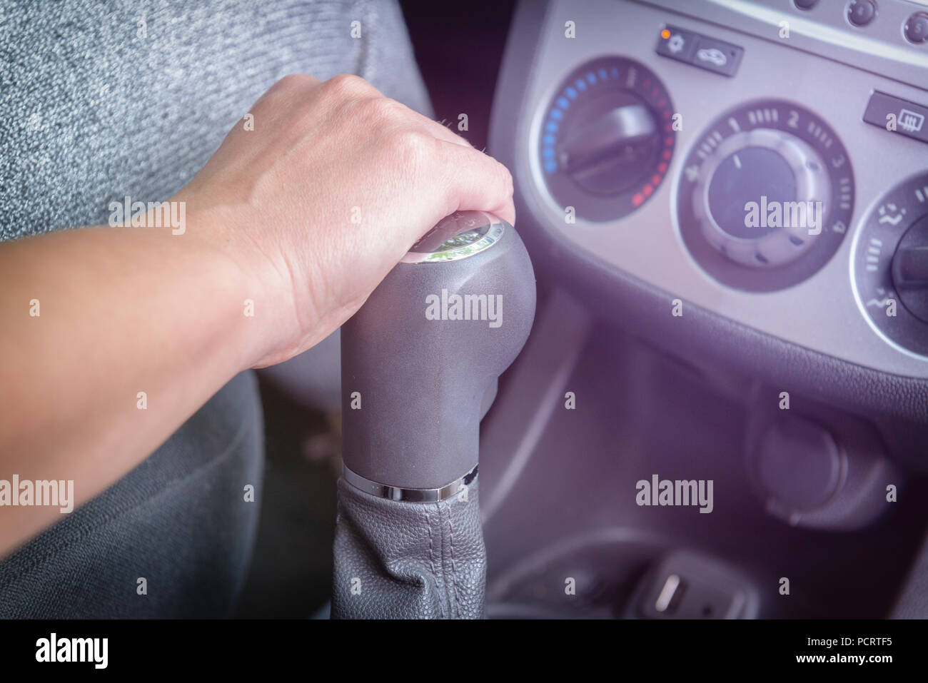 Driver's hand changing gear with gear shift lever. Operating manual