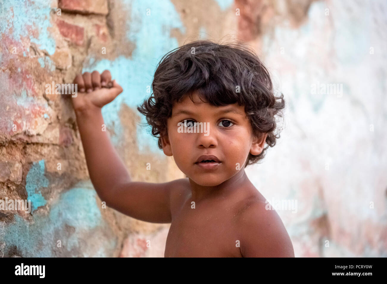 small Cuban boy in the street in front of an old wall, street scene in the historic city centre of Trinidad, Trinidad, Cuba, Sancti Spíritus, Cuba Stock Photo