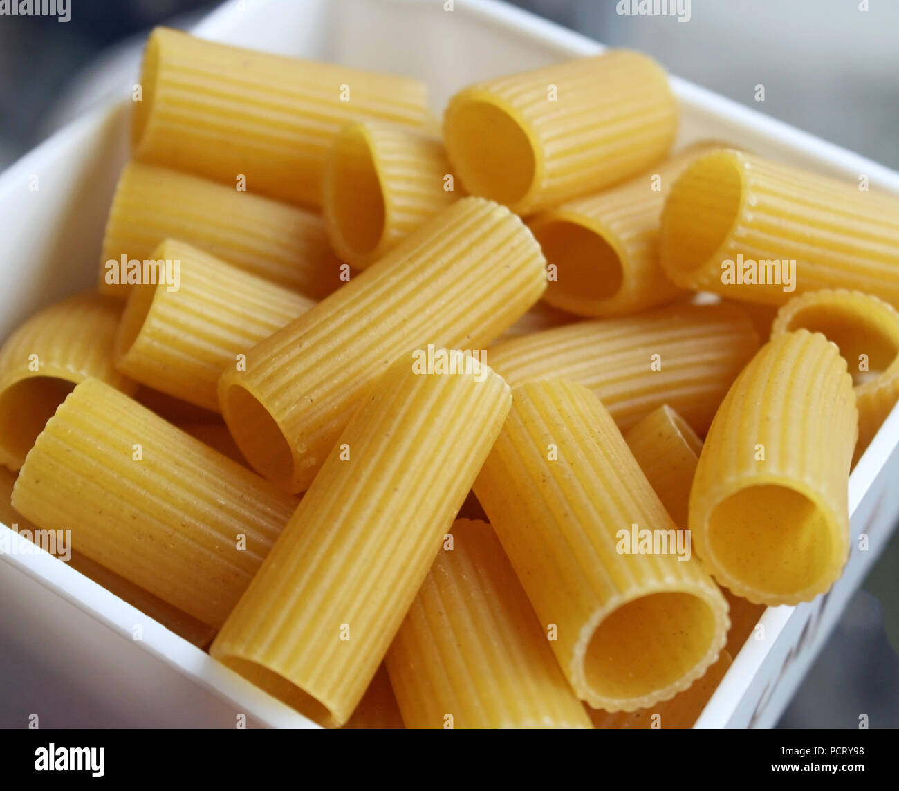 Measured portion of dry uncooked Rigatoni pasta Stock Photo