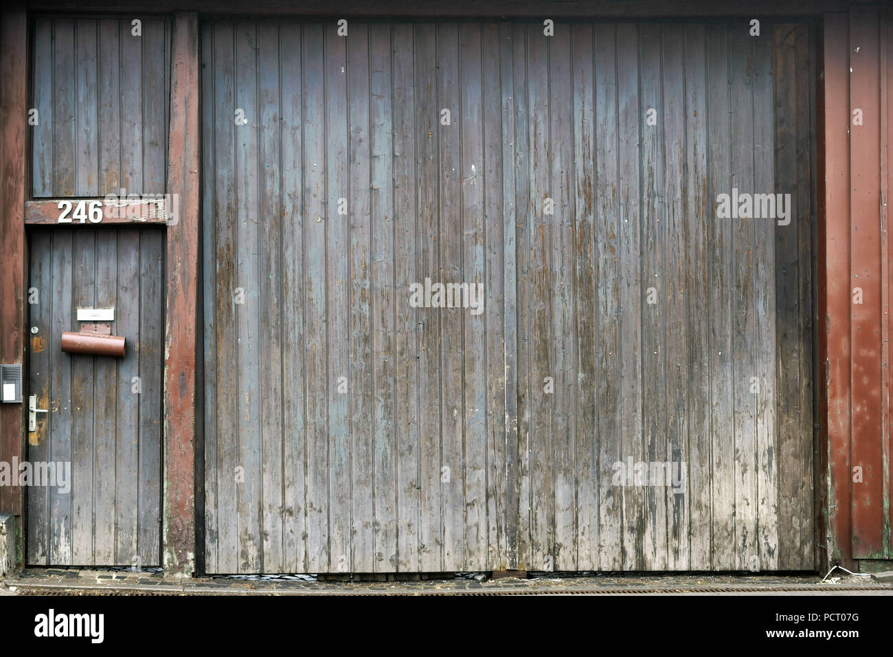 Large faded barn door with front door newspaper holder hires stock