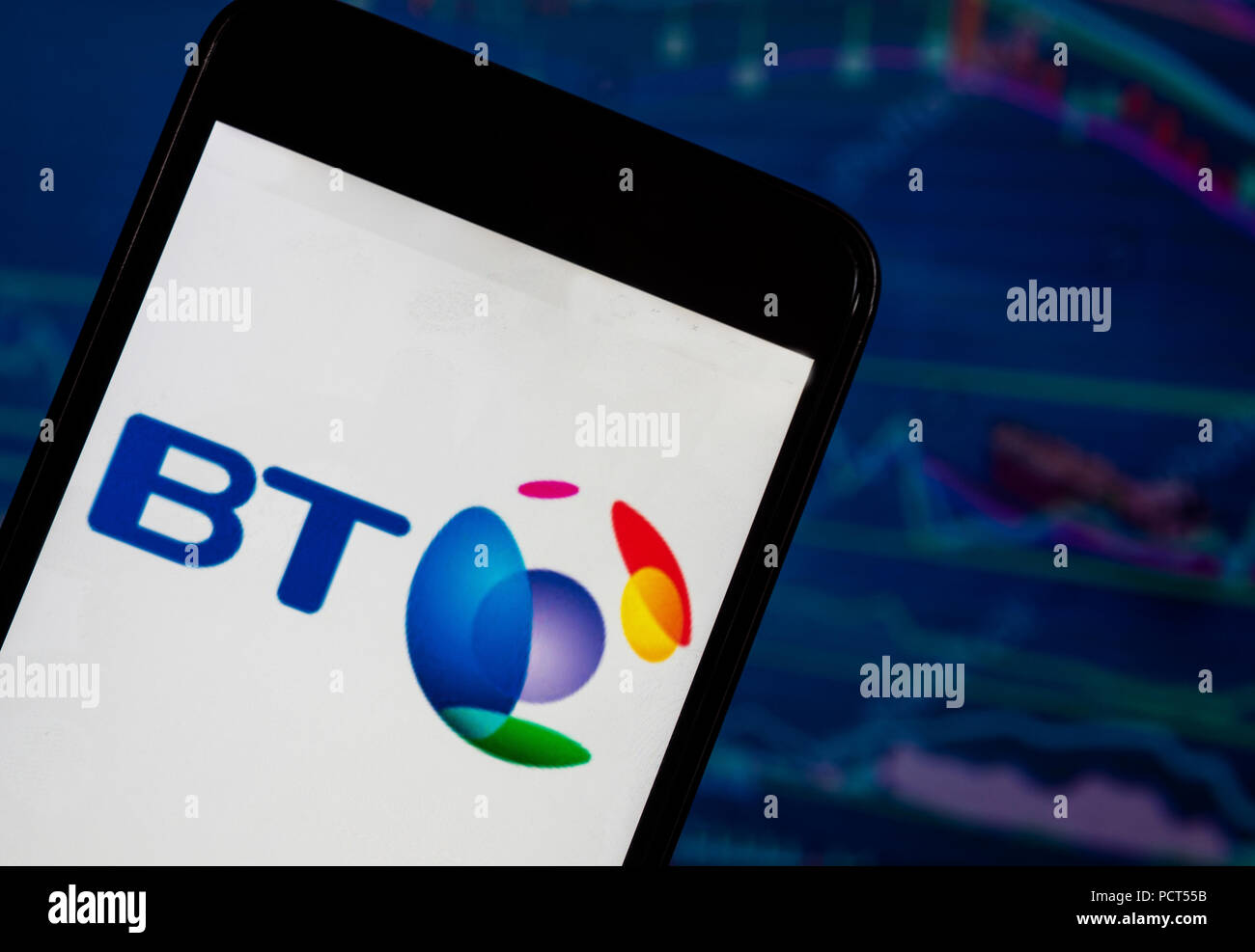 KIEV, UKRAINE - August 4, 2018: The British Telecom application seen  displayed on a smartphone with a background of a stock market shedle. BT  Group plc (trading as BT and formerly British