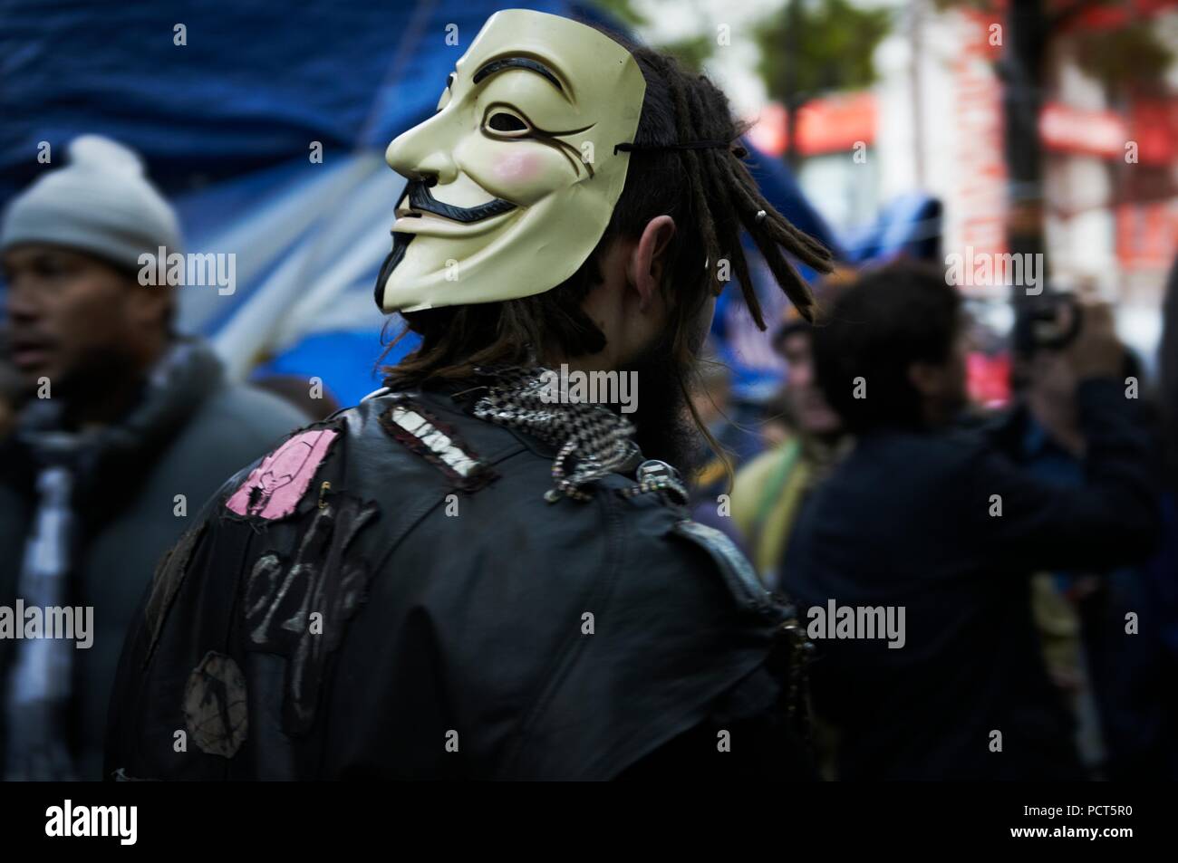 Protester wearing a V for vendetta Guy Fawkes mask. Occupy Wall Street  protest and movement, in Zuccotti Park, Wall Street New York Stock Photo -  Alamy