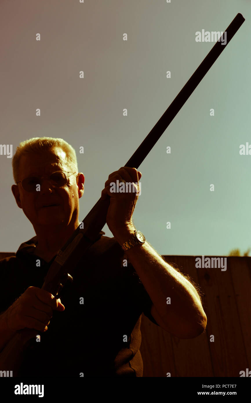 Man Holds 12 Gauge Shotgun Aloft, USA Stock Photo