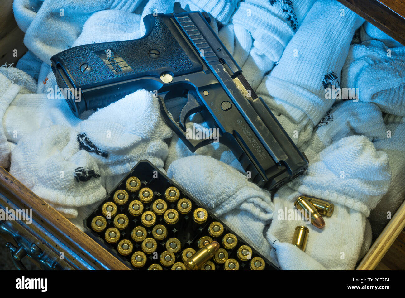 Semi-automatic pistol in sock drawer, USA Stock Photo