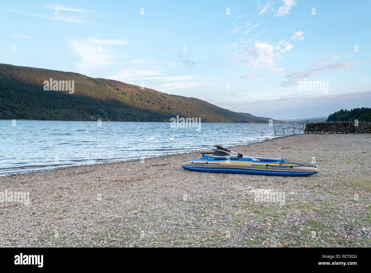 An image of an inflatable boat at the side of a lake, taken on a summer's evening at the Lake District, Cumbria, England, UK Stock Photo