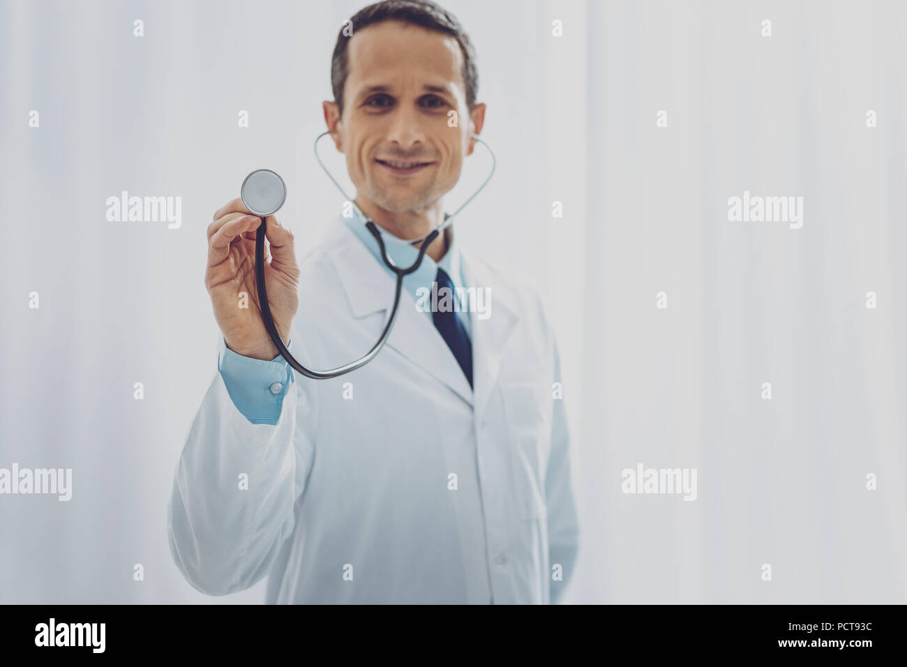 Joyful doctor demonstrating his instrument Stock Photo - Alamy