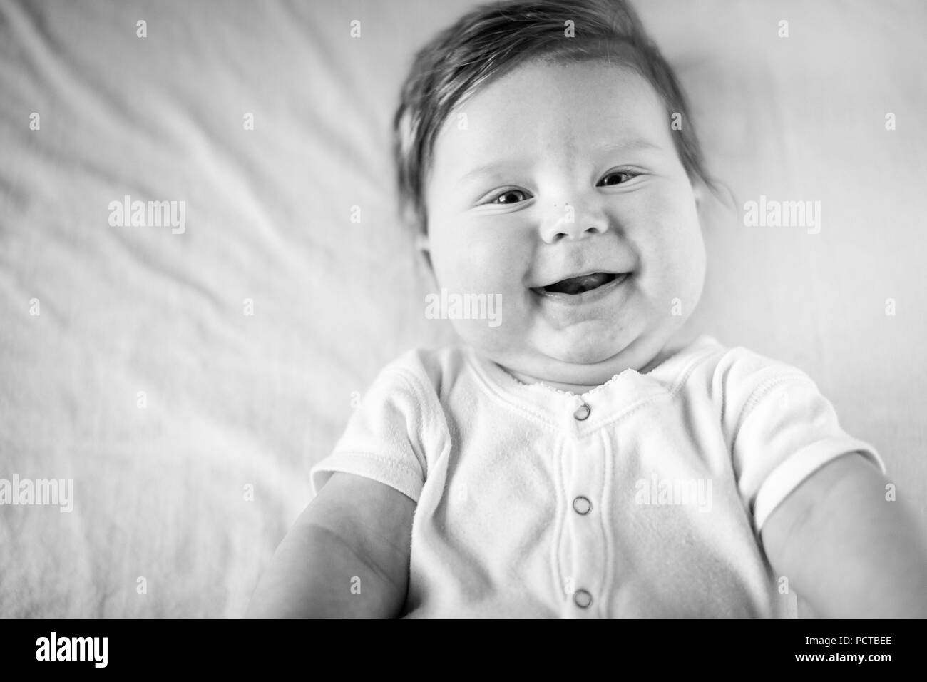 Baby, boy, laughing at the camera, black and white shot Stock Photo
