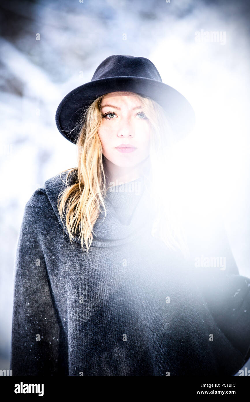 Young woman wearing hat and poncho looking seriously at the camera Stock Photo