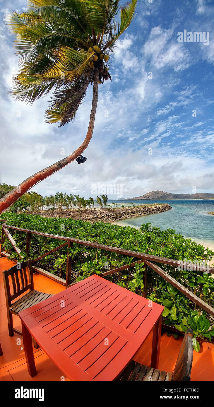 Fiji, Taweva Island, table and chairs on a balcony on the beach, palm