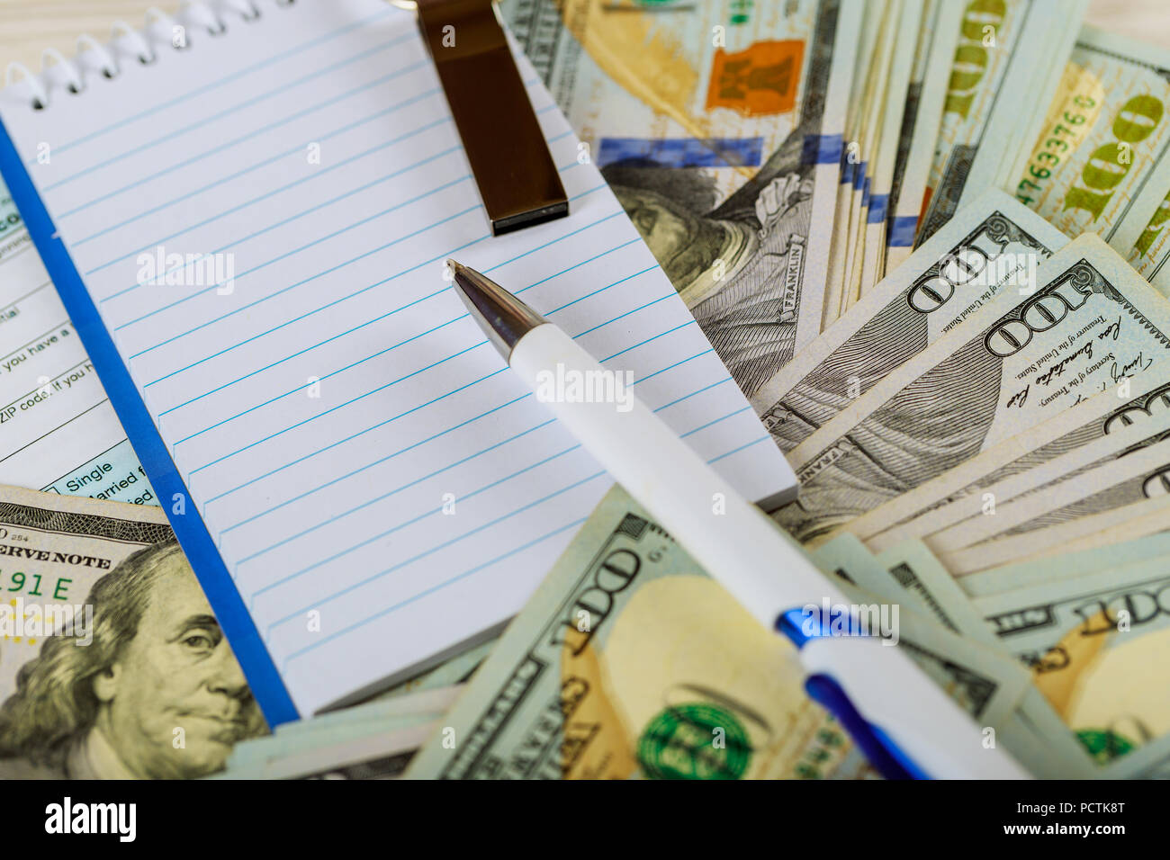 white notebook lie on the background of dollar bills. Space for text ...