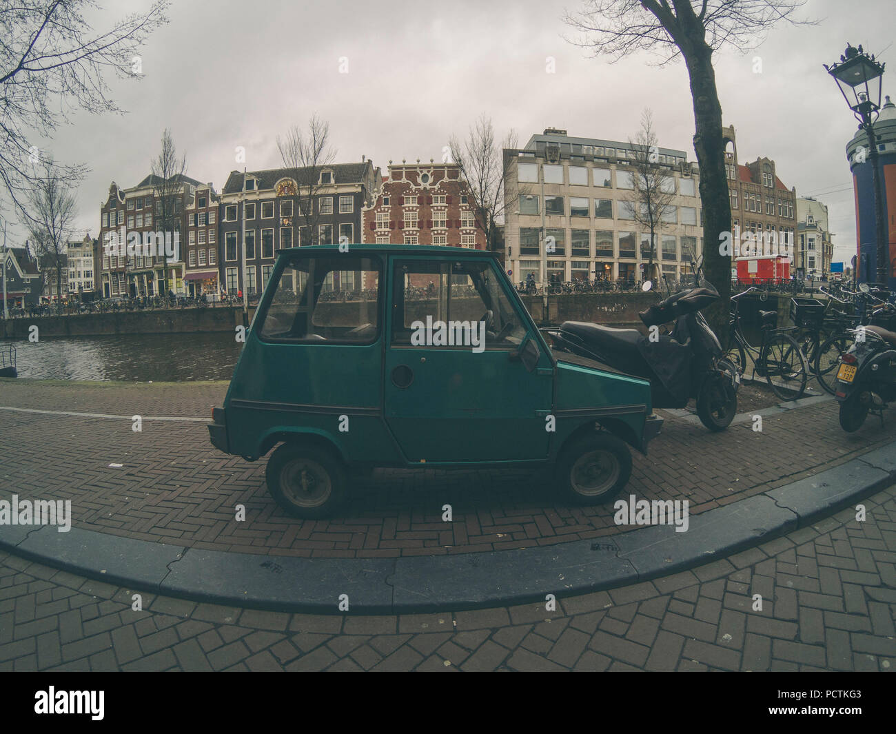 Tiny green car parked on Amsterdam streets Stock Photo
