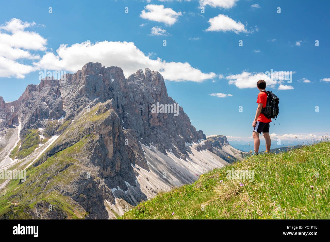 Hiker on the ridge of Mount Medalges looking to the Odle / Geisler Group, Funes Valley, Puez-Geisler Nature Park, Dolomites, Bolzano, South Tyrol, Italy Stock Photo
