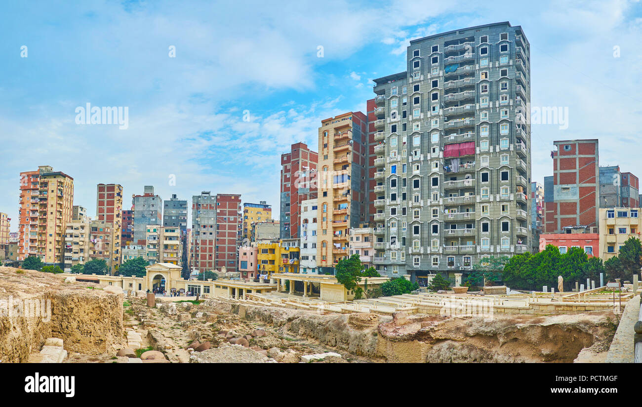 Panorama of stone foundation of ruined Greek Serapeum Temple with the high-rises of Karmouz on background, Alexandria, Egypt. Stock Photo