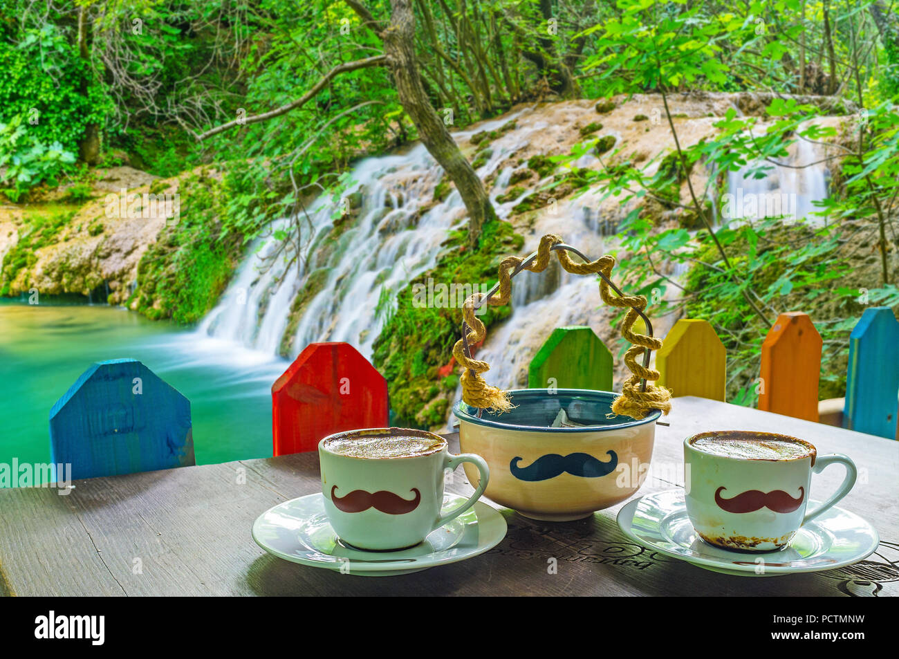 AKSU, TURKEY - MAY 9, 2017: The bank of Kursunlu waterfall is perfect place to enjoy the hot Turkish coffee in Osmanli cafe with its funny mustache ta Stock Photo