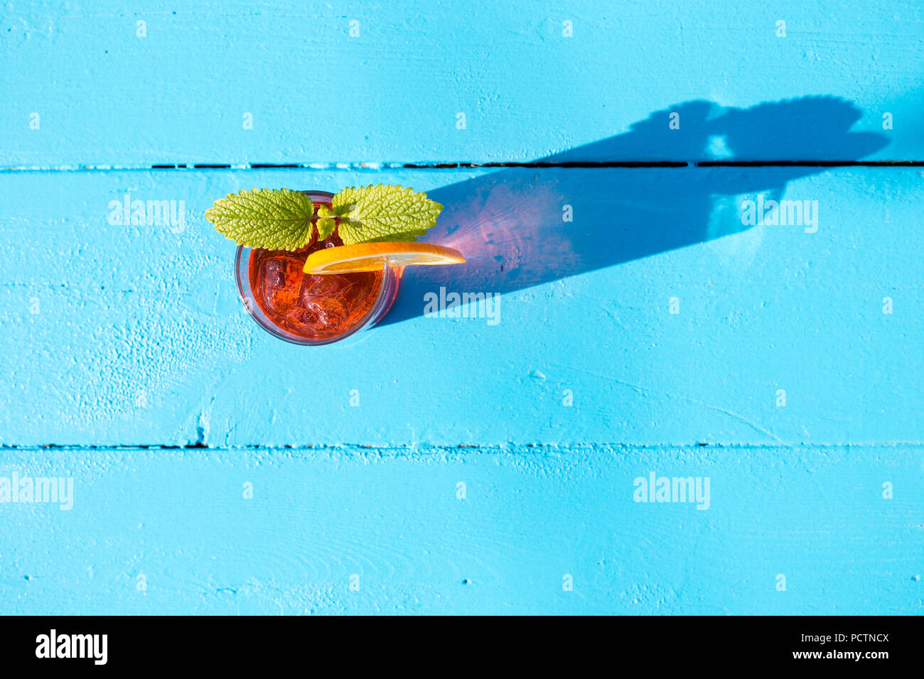 Glass of aperol spritz with mint and a orange slice on a sunny day. Stock Photo