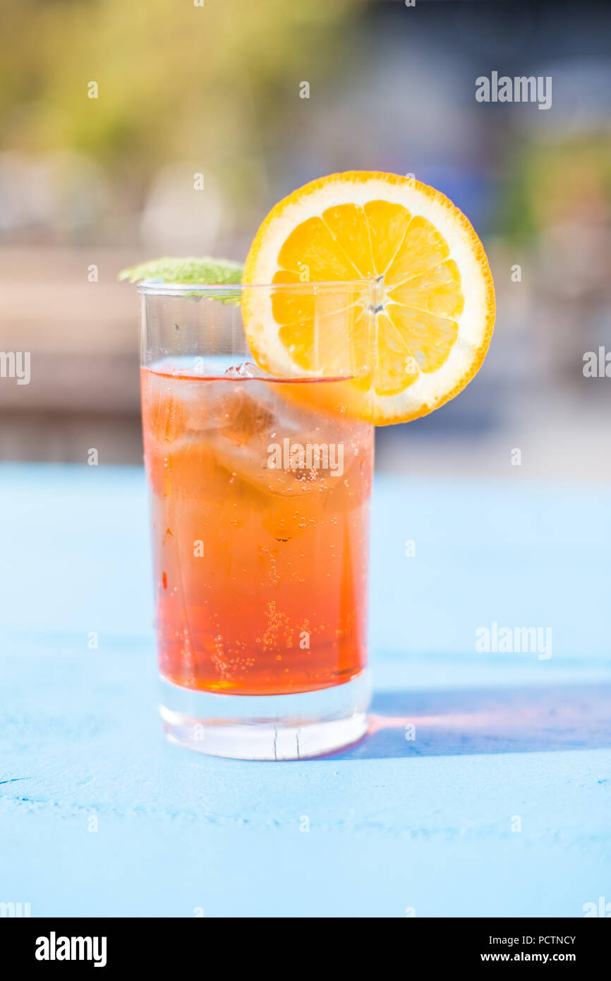 Glass of aperol spritz with mint and a orange slice on a sunny day. Stock Photo