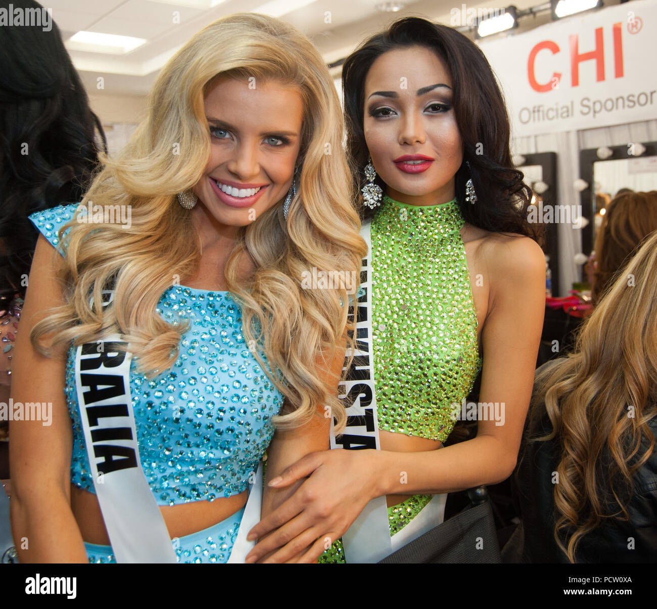 DORAL, FL - JANUARY 25:  Tegan Martin, Miss Australia, Aiday Issayeva, Miss Kazakhstan 2014 gets her makeup done by an O.P Makeup artist backstage at the 63rd Annual Miss Universe Pageant at Trump National Doral on January 25, 2015 in Doral, Florida.  People:  Tegan Martin, Miss Australia, Aiday Issayeva, Miss Kazakhstan Stock Photo