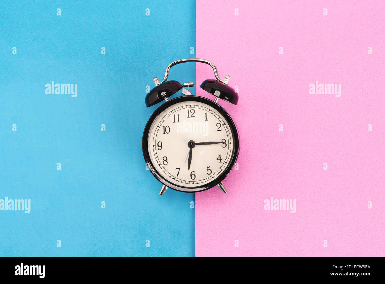 Vintage alarm clock on pink and blue background Stock Photo Alamy