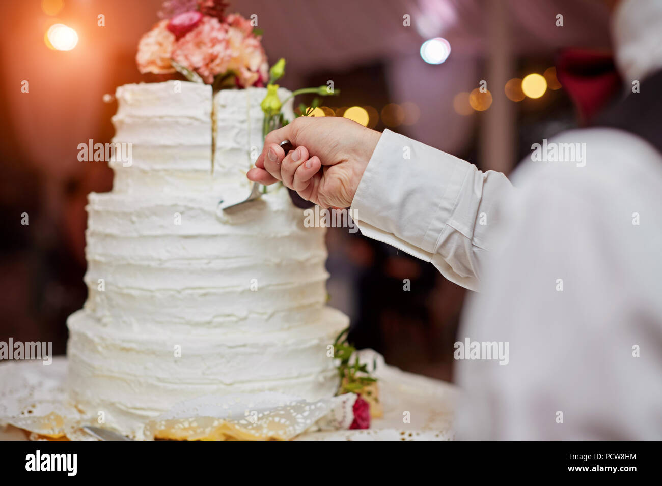 bride and a groom is cutting their wedding cake. beautiful cake. nicel light. wedding concept Stock Photo