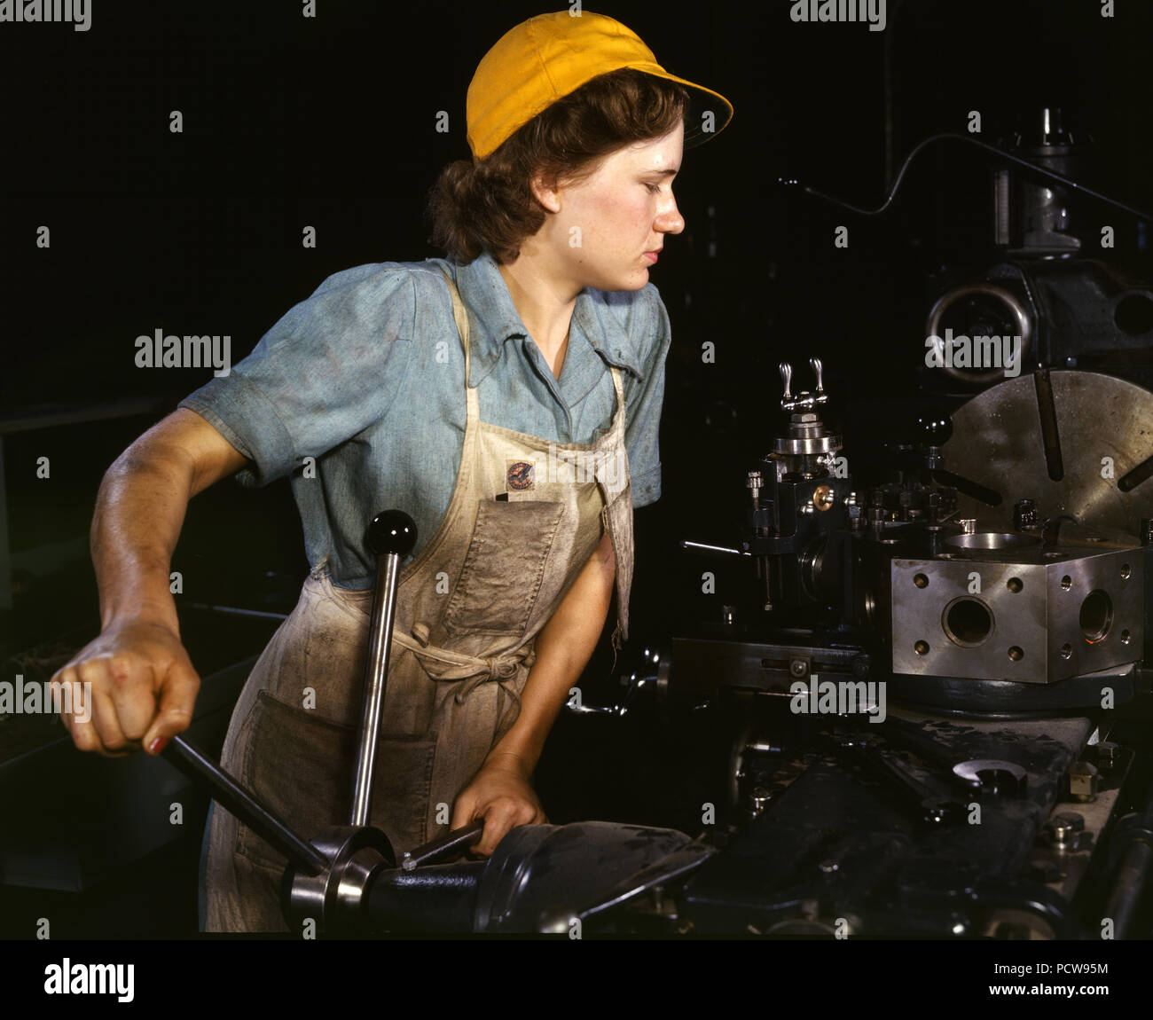 Lathe operator machining parts for transport planes at the Consolidated