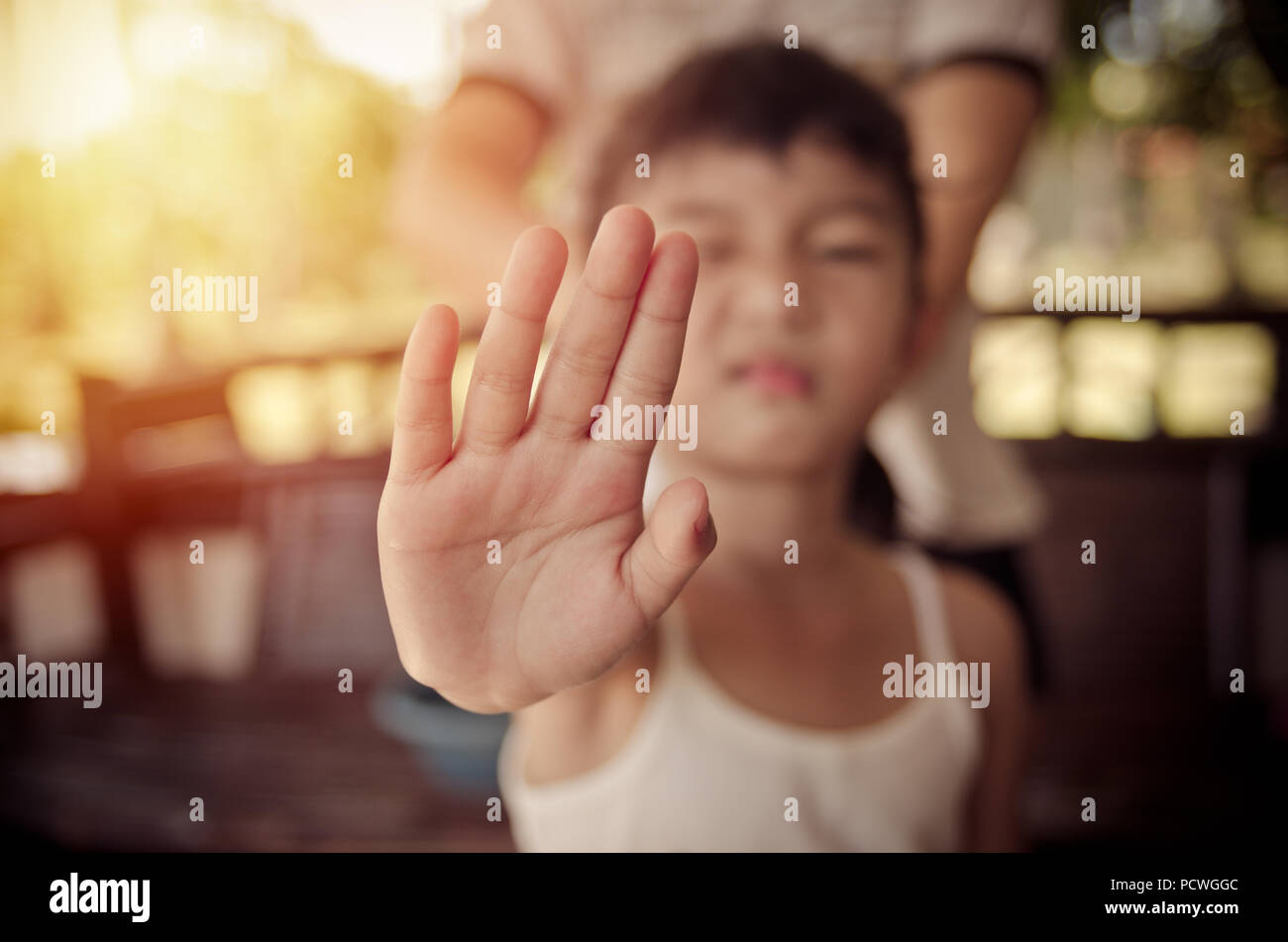 A girl showing an open hand signal that means stop or wait isolated on a blurred background Stock Photo