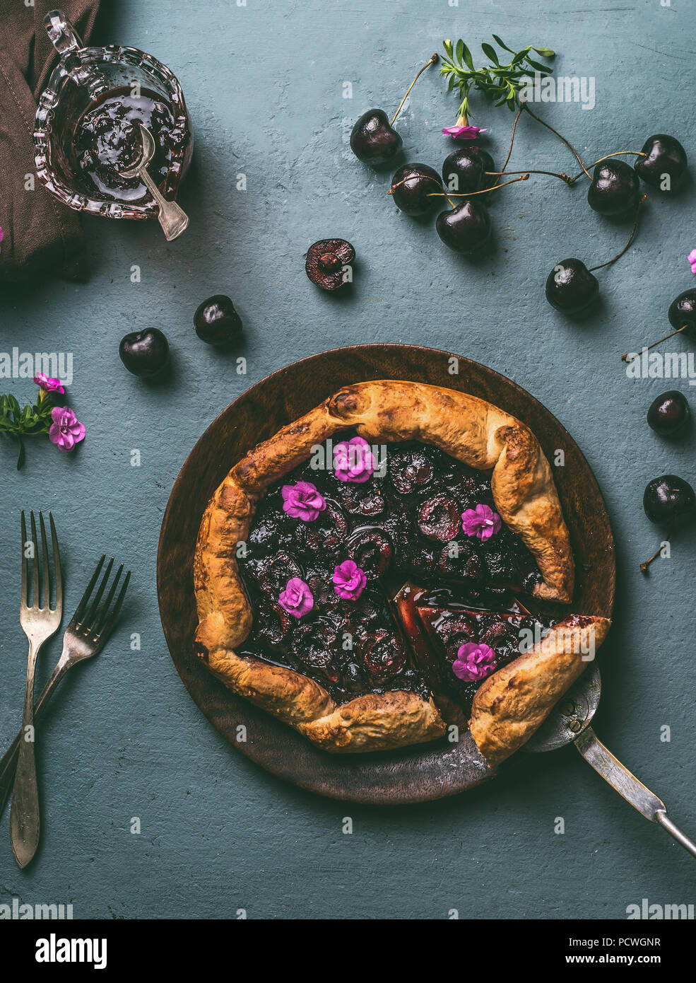 Homemade cherry pie on wooden plate and rustic kitchen table background ...