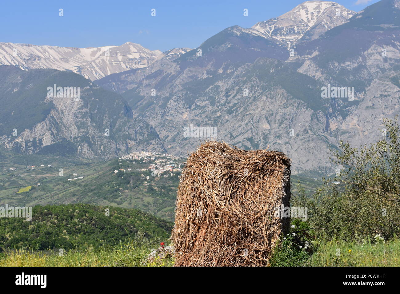 Single Hay bale overlooking the hill top town of Fara San Martino, with the  Maiella Mountains  in the background.- Abruzzo - Italy Stock Photo