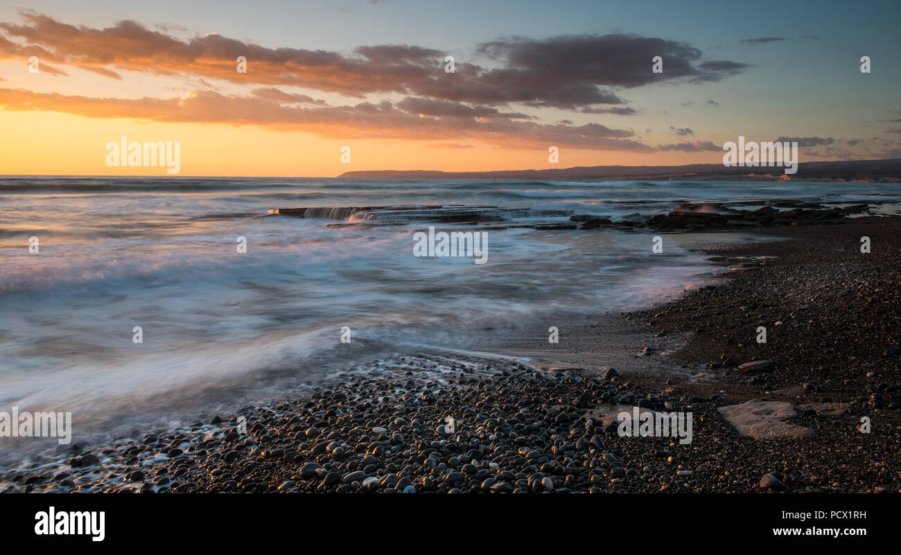 Dramatic beautiful sunset on a rocky coast at Akrotiri area in Limassol, Cyprus. Long exposure photography Stock Photo