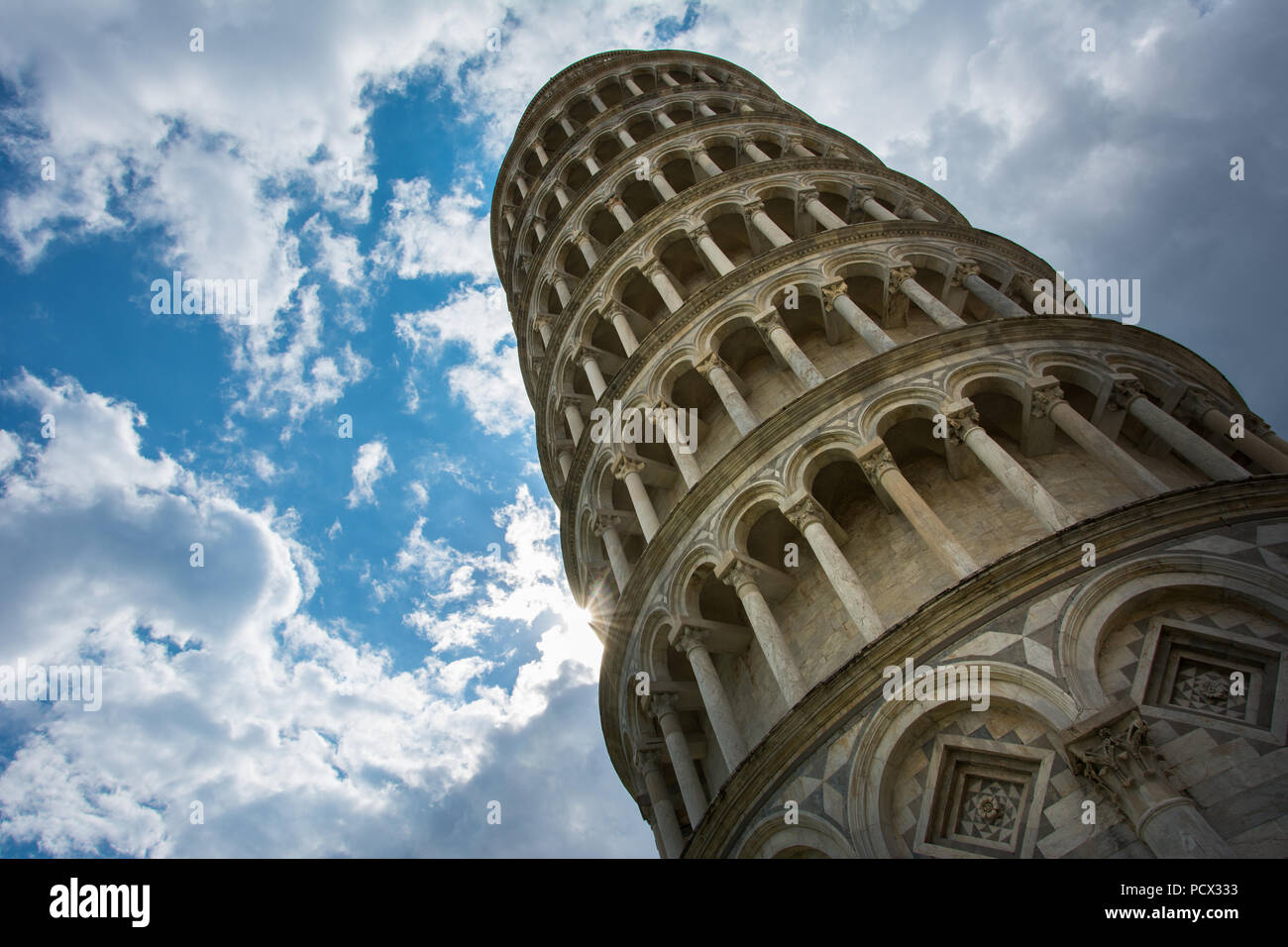 The Leaning Tower of Pisa, Italy, famous for its tilt, with the cloudy sky.  The tower is originally a bell tower of the nearby Pisa Cathedral Stock Photo