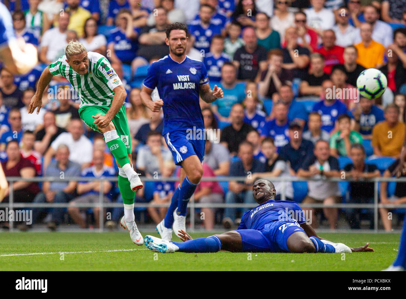 Cardiff, Wales, UK. 4th August 2018. Joaquin of Real Betis shoots under pressure from Sol Bamba of Cardiff City during the pre-season friendly match between Cardiff City of the Premier League and Real Betis of La Liga at Cardiff City Stadium. Credit: Mark Hawkins/Alamy Live News Stock Photo