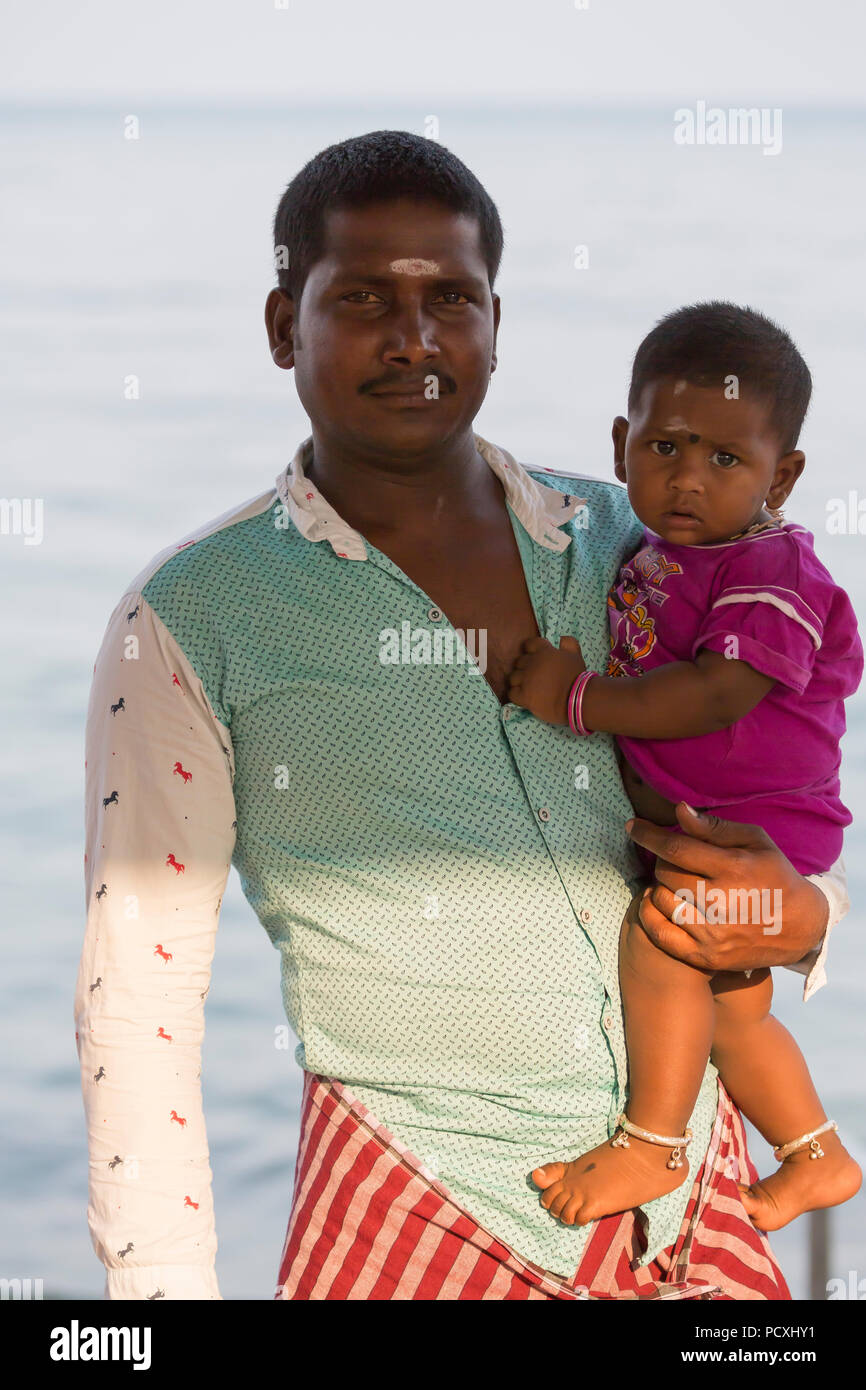 RAMESHWARAM, TAMIL NADU, INDIA - MARCH CIRCA, 2018. Smiling indian child in the arms of his father. Stock Photo