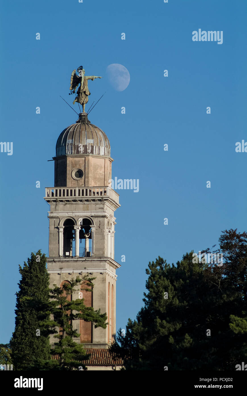 UDINE, ITALY, JULY 25, 2007: The angel on the steeple of the Church of Santa Maria di Castello in Udine pointing to the moon. Stock Photo