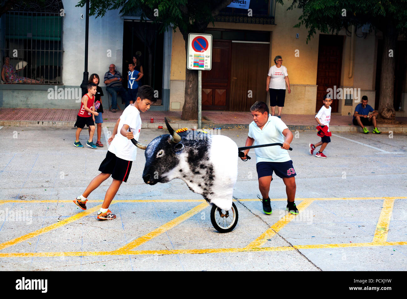 Boys sharpening their bull running with a practise bull in the main square, Cherta, Spain. Stock Photo