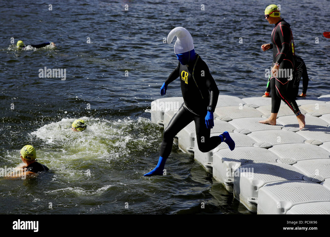 A competitor dressed as a smurf cartoon character in the Weekend Warrior wave in the AJ Bell London Triathlon at the Royal Victoria Docks in east London. Stock Photo