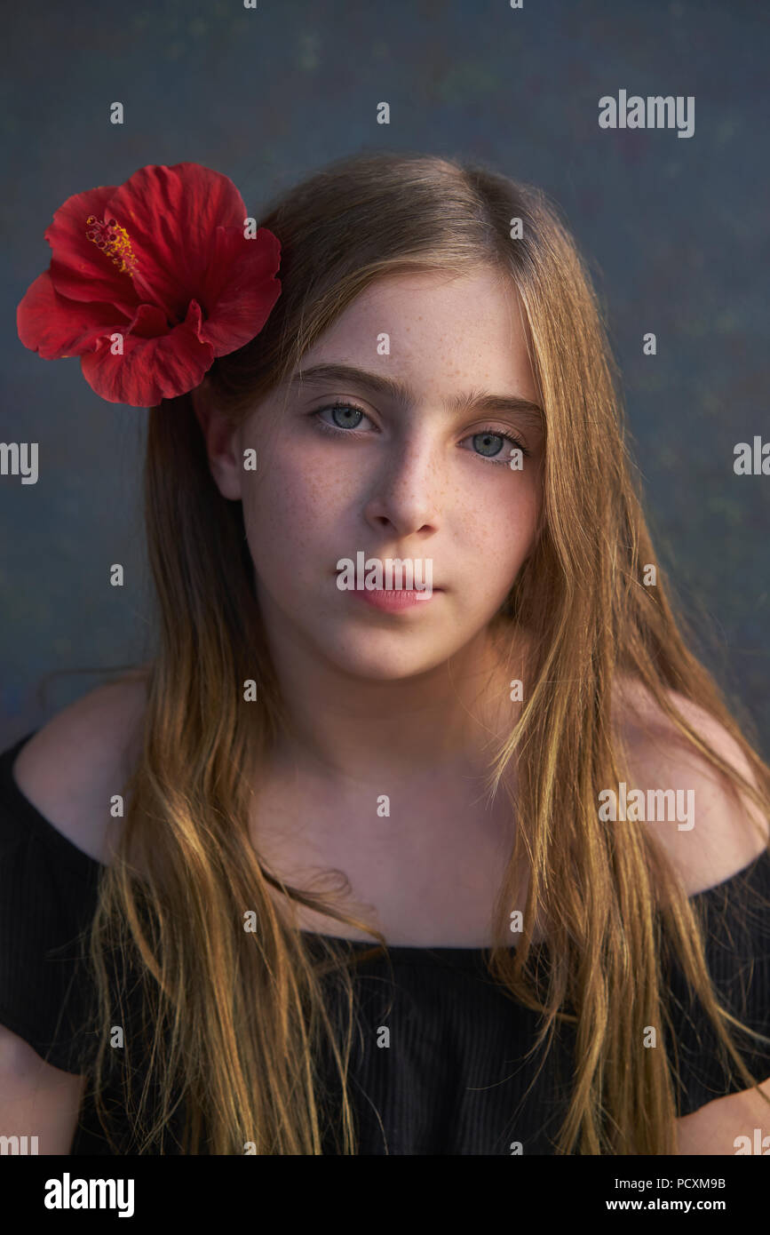 Blond kid girl portrait with hibiscus red flower on hair Stock Photo ...