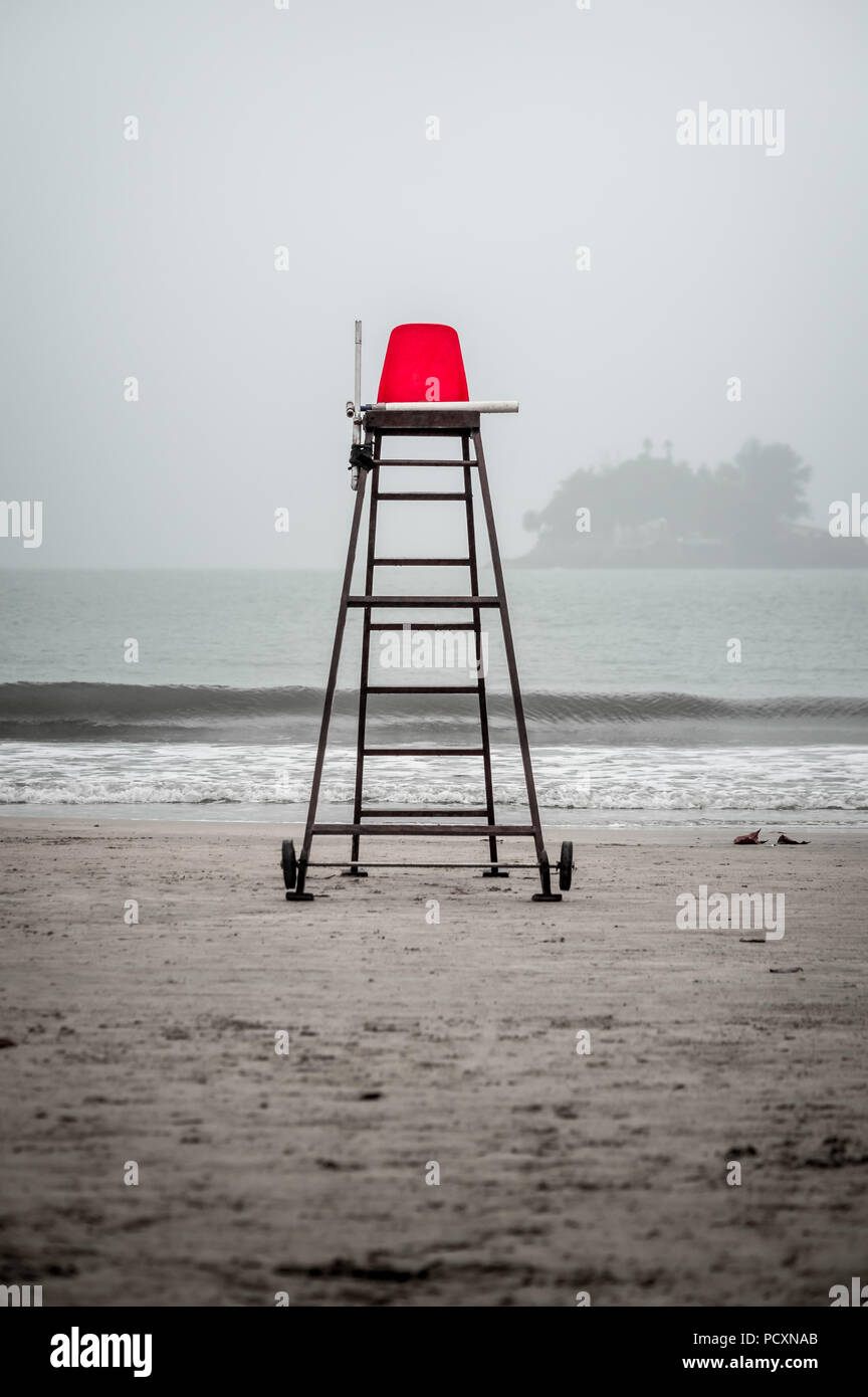 Empty Life guard red chair on the beach on a rainy day Stock Photo