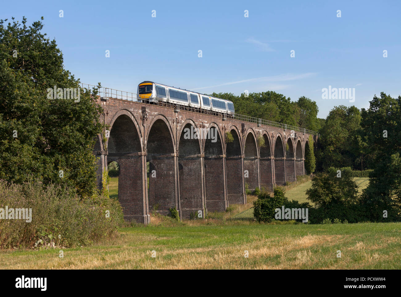 A Chiltern railways class 168 turbostar train crossing  Saunderton Viaduct (south of Banbury) with a London to Birmingham Snow hill express Stock Photo