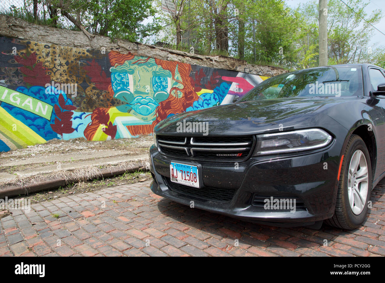 DETROIT, MICHIGAN, UNITED STATES - MAY 22nd 2018: Black Dodge Charger in front of an wall with graffiti in downtown Detroit Stock Photo