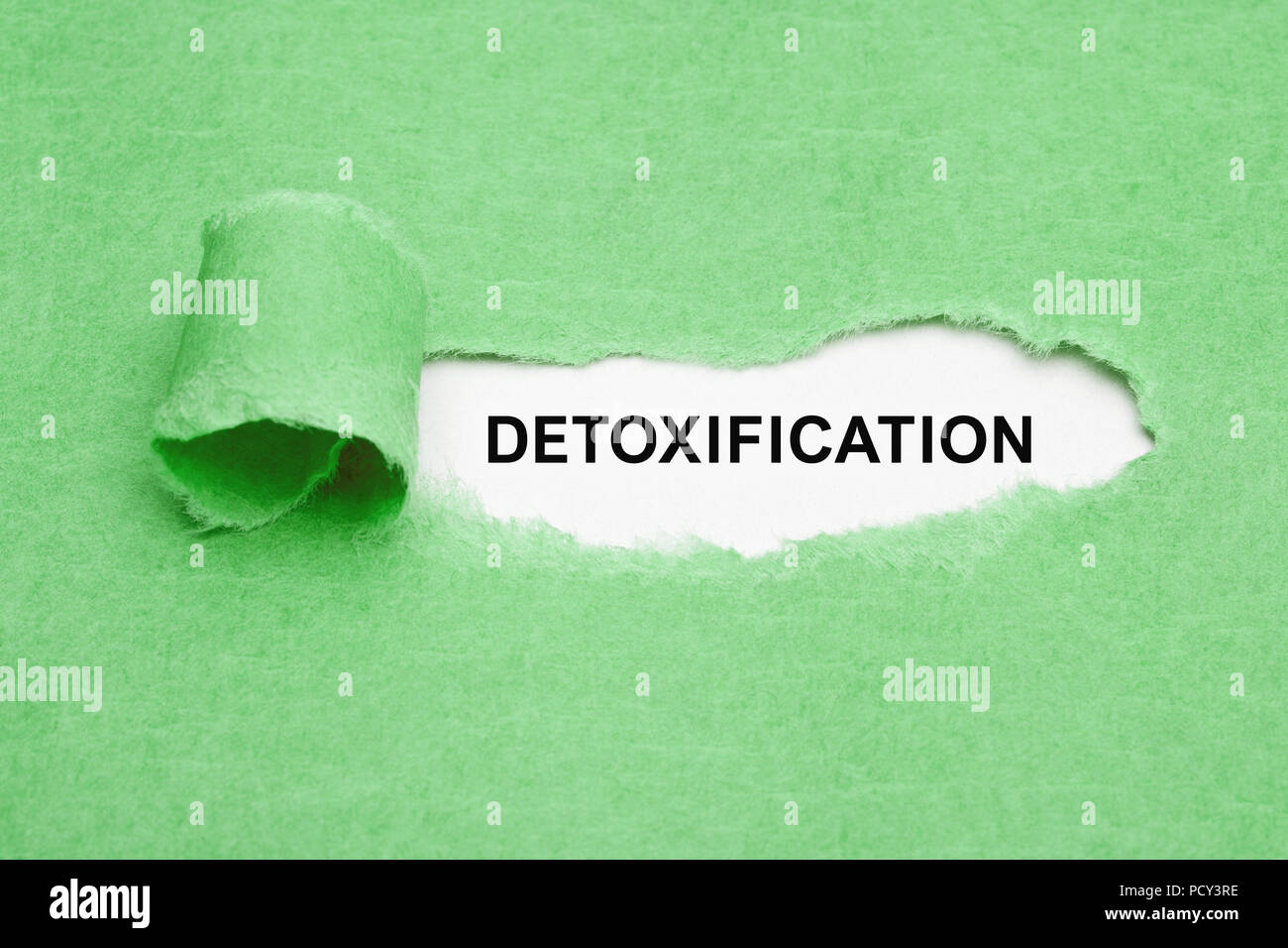The word Detoxification appearing behind ripped green paper. Stock Photo