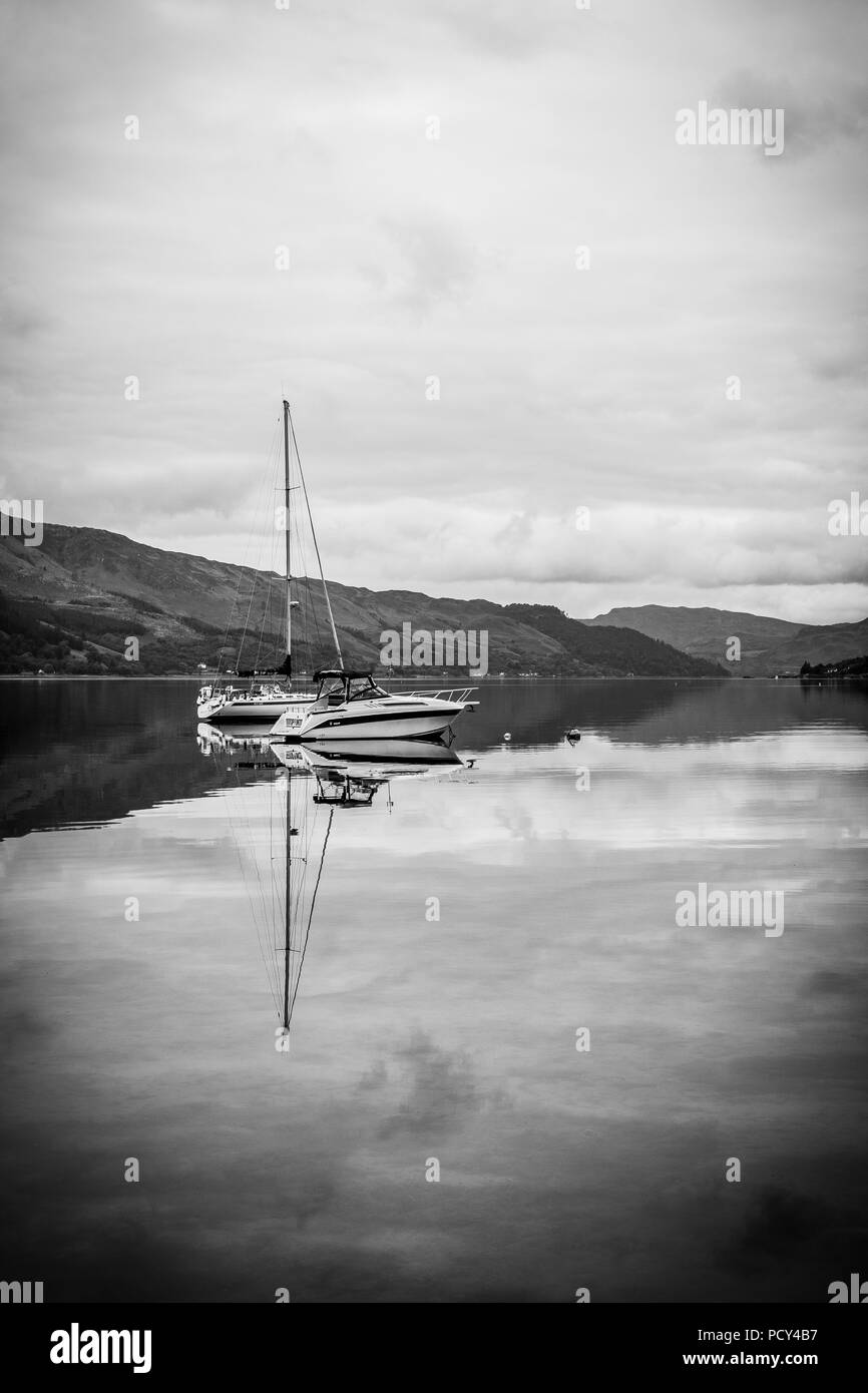 Yacht reflecting on the waters of Kintail Stock Photo