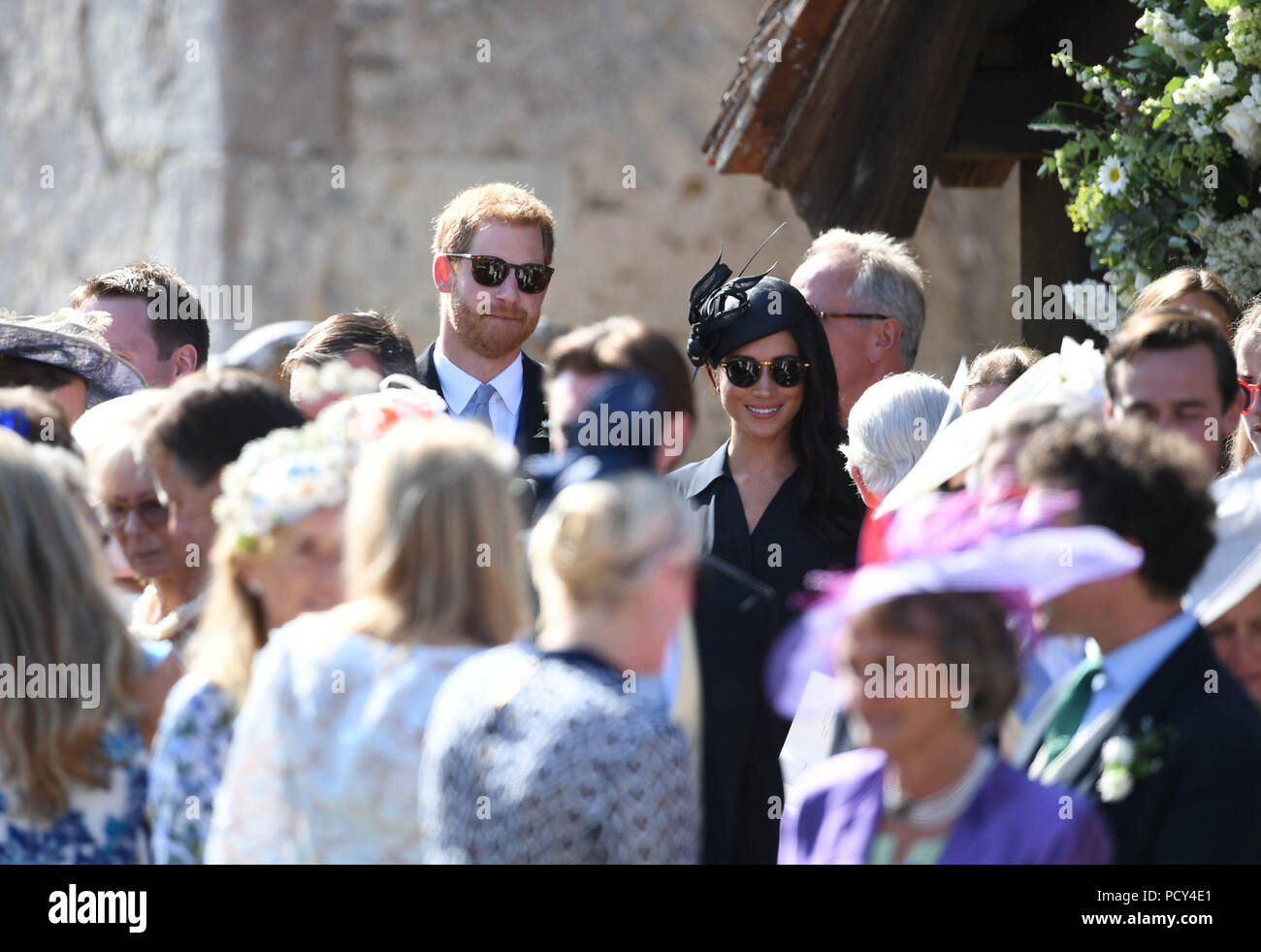 The Duke and Duchess of Sussex outside St Mary the Virgin Church in Frensham, Surrey, after attending the wedding of Charlie van Straubenzee and Daisy Jenks. Stock Photo