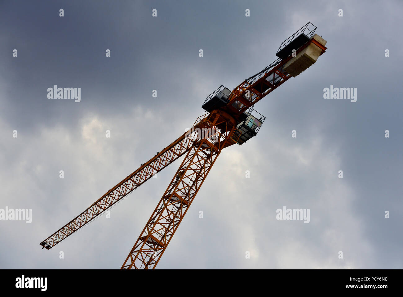 High rise tower construction crane against dark foreboding sky Stock Photo