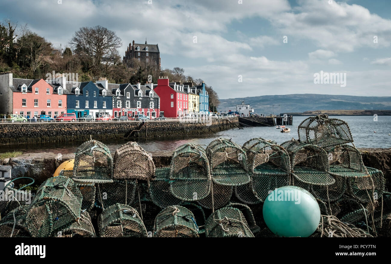 Lobster traps on a quay wall with the colorful town of Tobermory in the background, Wednesday 11 April 2018, Isle of Mull, Scotland Stock Photo