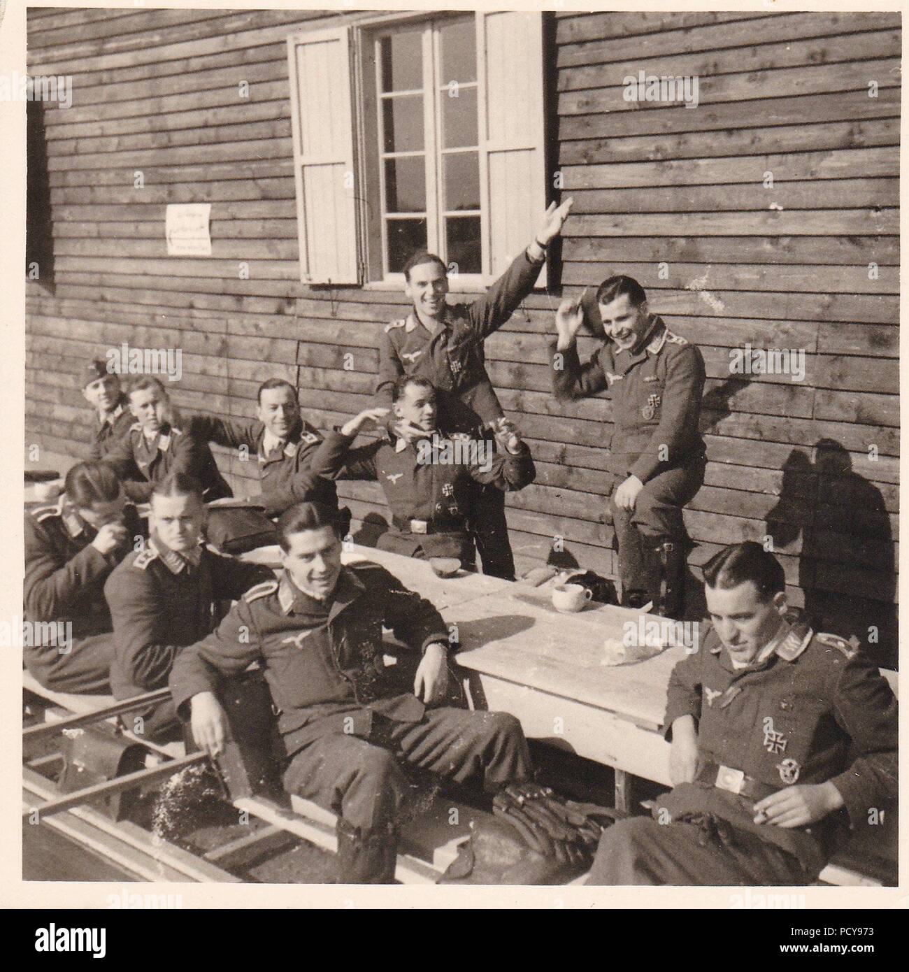 Oberfeldwebel Karl Müller (at rear, standing with arm raised high) relaxes with other aircrew of 1. Staffel, Kampfgeschwader 2 during a stopover at Bucharest during the Balkan Campaign in 1941. Müller was awarded the Knight's Cross of the Iron Cross on 15th October 1942. Stock Photo