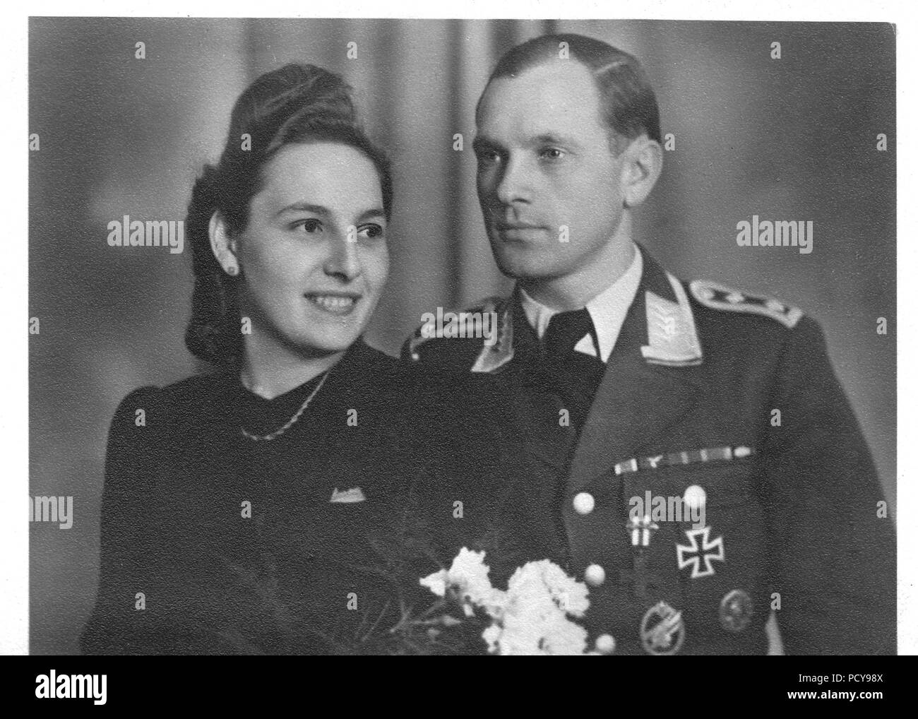 Oberfeldwebel Otto Thomas of 3. Kompanie, Fallschirmjäger-Regiment 2 and his wife Else pose for the camera on their wedding day in December 1942. Otto Thomas wears the ribbons for: the Iron Cross 2nd Class; Long Service Medal IV Class; East Medal; March 13th 1938 Commemorative Medal; October 1st 1938 Commemorative Medal with Prague Castle Bar. On his chest Otto Thomas wears the Italian Croce Al Valor Militare (Cross for Military Valour) with Gallantry Sword on the ribbon; Iron Cross 1st Class; Army Paratrooper Award Badge; Wound Badge in Black. Stock Photo