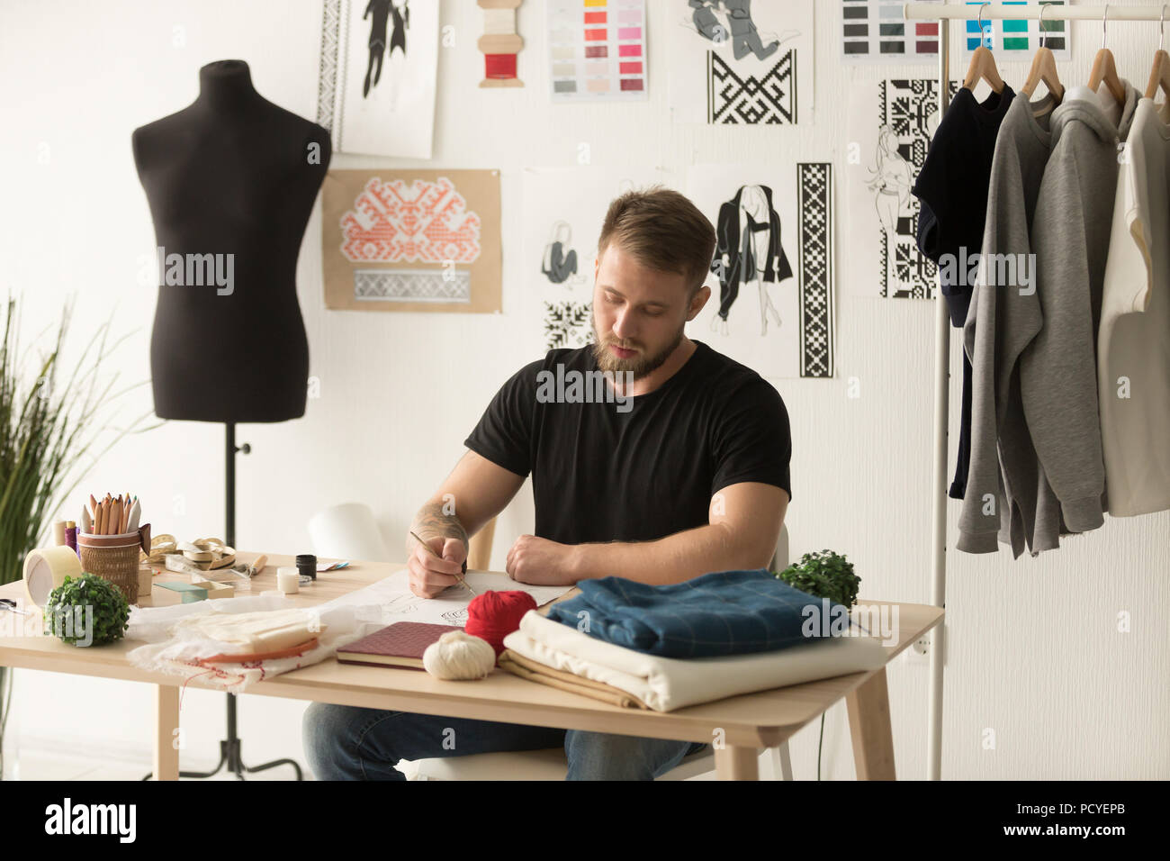 Serious male designer creating new ethnic clothing line Stock Photo