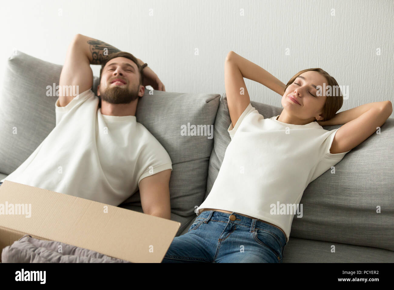 Relaxed couple lying on sofa happy to move in Stock Photo