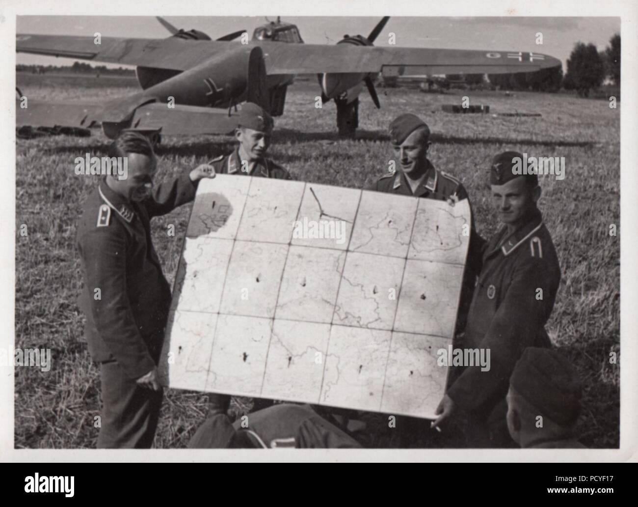 Image from the photo album of Oberfeldwebel Gotthilf Benseler of 9. Staffel, Kampfgeschwader 3: Aircrew of 9. Staffel, Kampfgeschwader 3 hold up a map of western Poland, during the campaign against Poland in September 1939. In the background is one of the Dornier Do 17Z-2s of 9./KG 3. Stock Photo